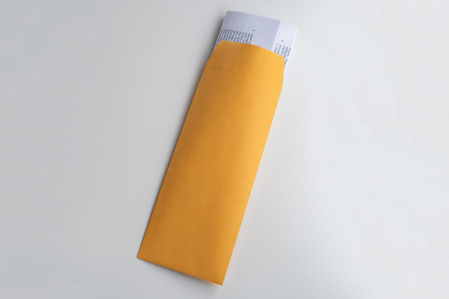 Yellow policy envelope with folded documents sticking out the top.
